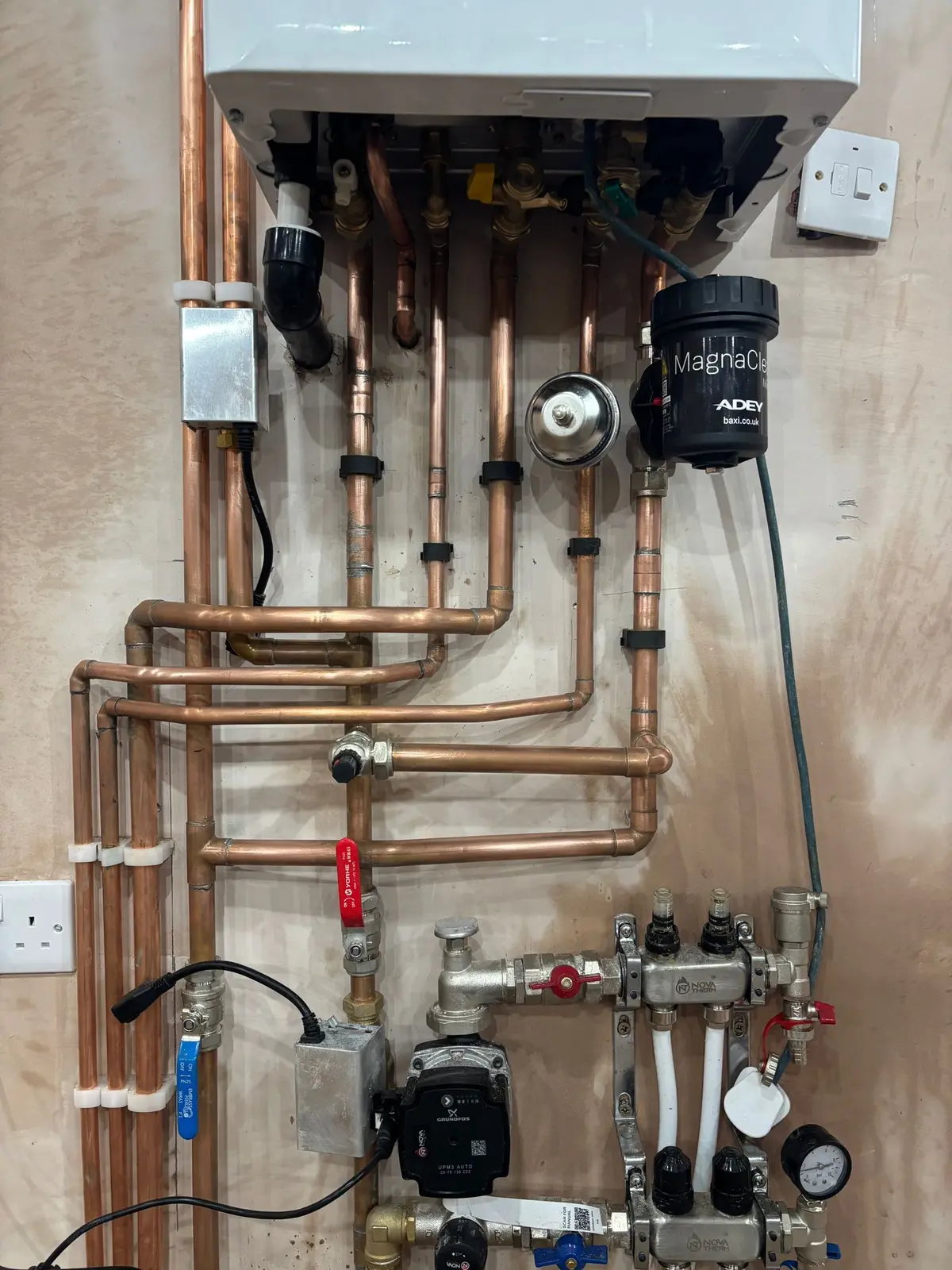 Underfloor heating manifold with circulating pump and flow gauges, piped in copper to the boiler with a MagnaClean filter